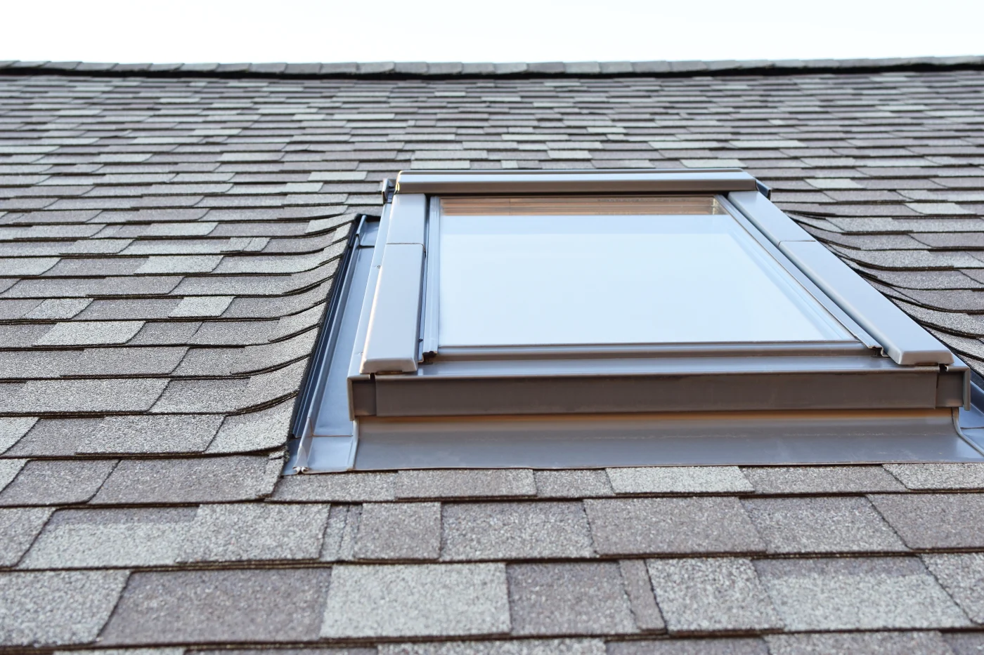 A shingle roof with a skylight.