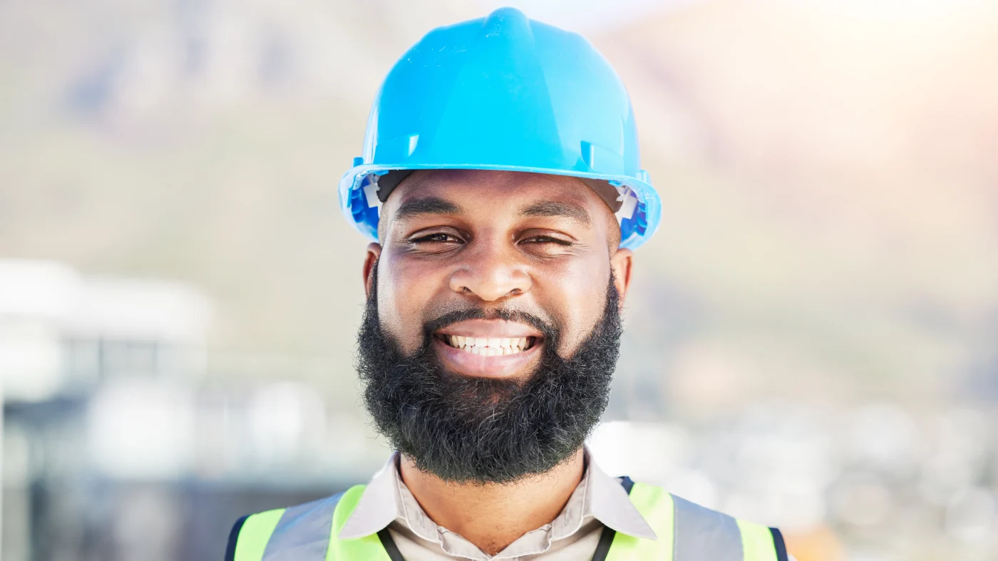 A smiling roofing contractor faces the camera