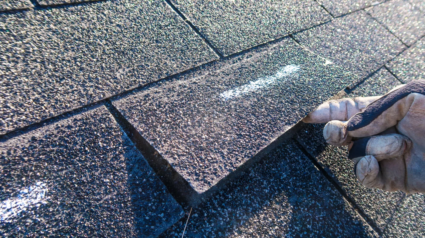 A roofer completes an inspection as part of storm damage roof repair.
