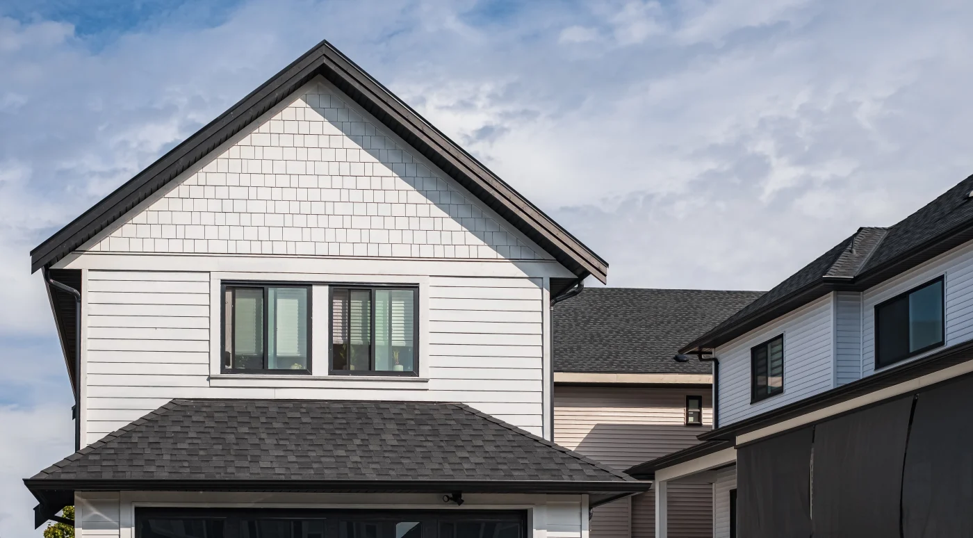 A home with white siding and a dark gray shingle roof.