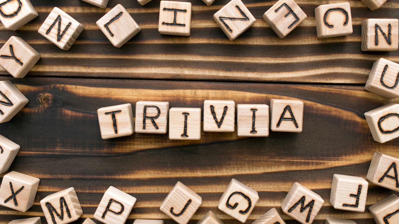 Letter tiles are arranged on a table with the ones in the center spelling TRIVIA