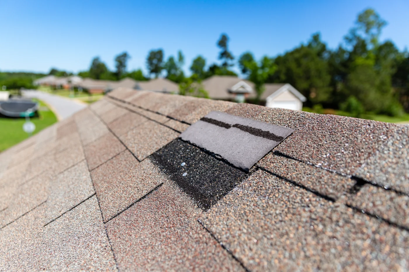 Close-up of a shingle roof with one misplaced shingle needing repair.