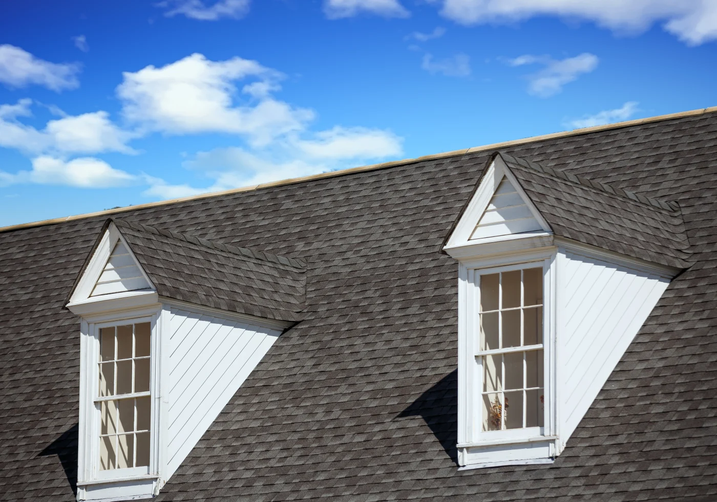 A gray shingle roof with two dormers.