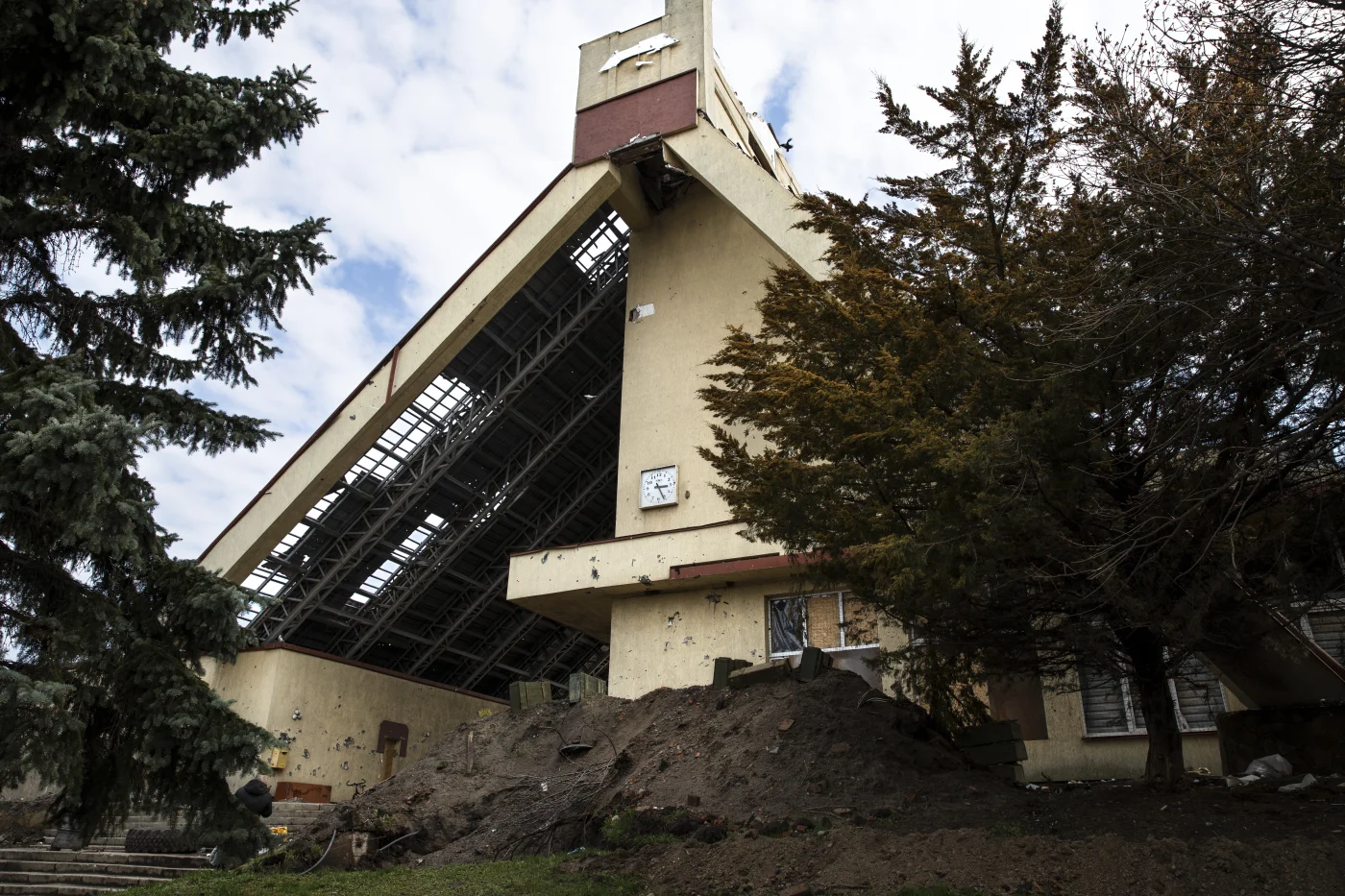 Severely damaged building in Boulder, CO with a partially collapsed roof and debris scattered around the base
