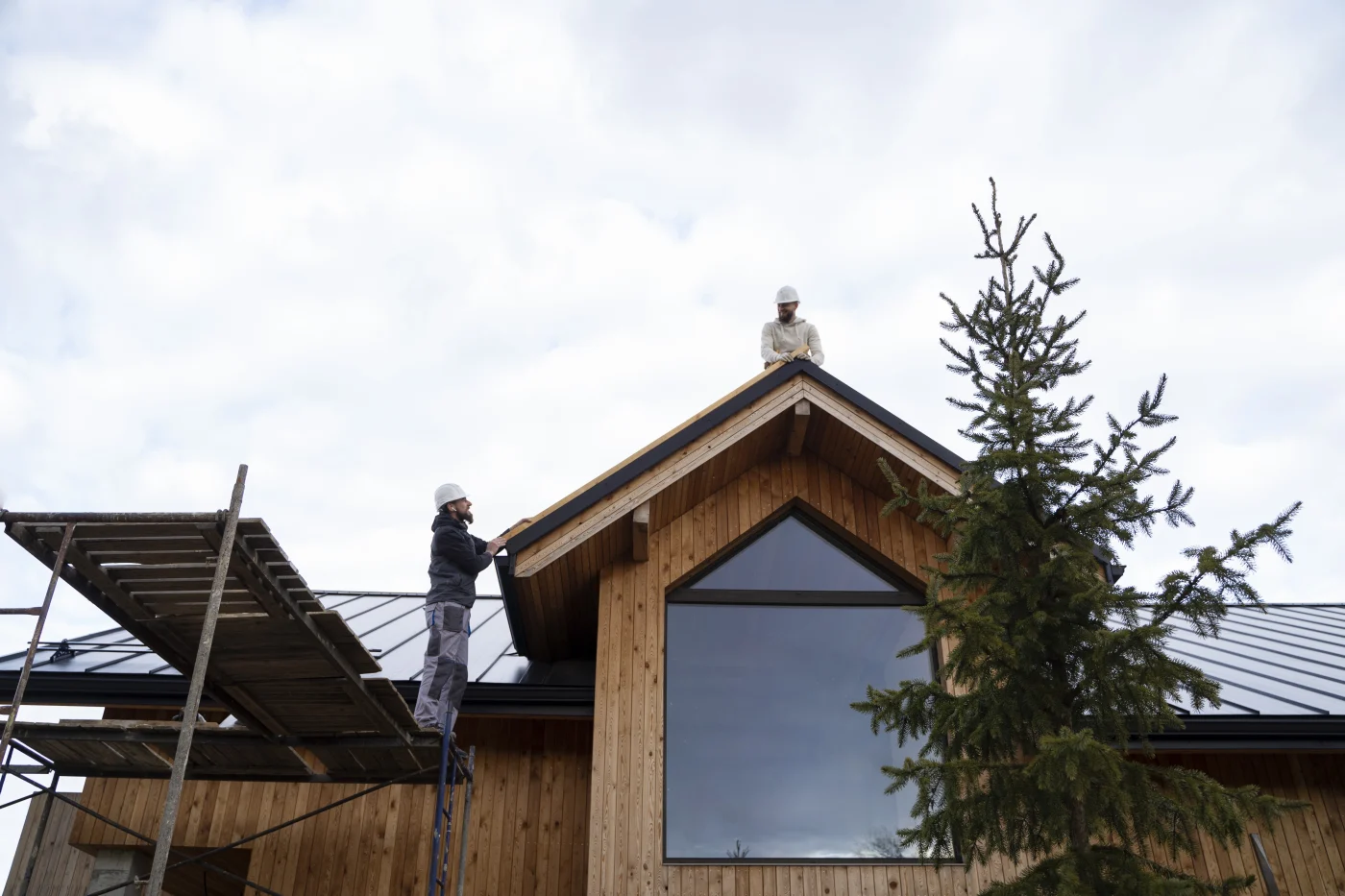 Two roofing professionals from Columbine Roofing & Solar perform storm damage roof repairs on a Northern Colorado home.